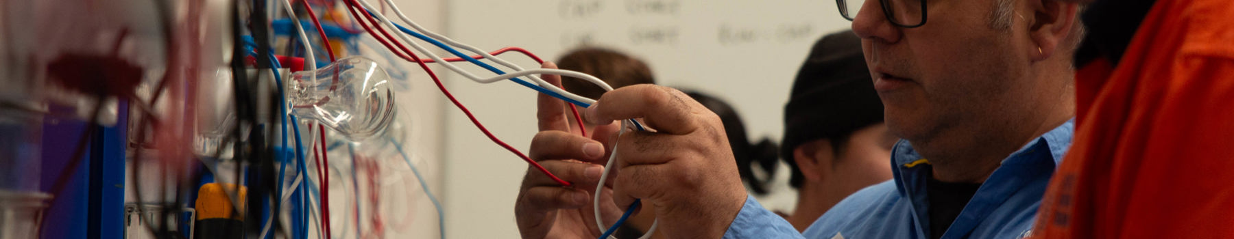 Trainer demonstrating wiring on an electrotechnology training board at CET’s Electrical Pre-Apprenticeship (Perth, WA)