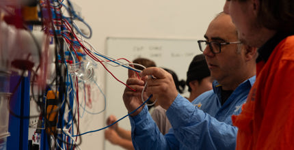 Trainer demonstrating wiring on an electrotechnology training board at CET’s Electrical Pre-Apprenticeship (Perth, WA)